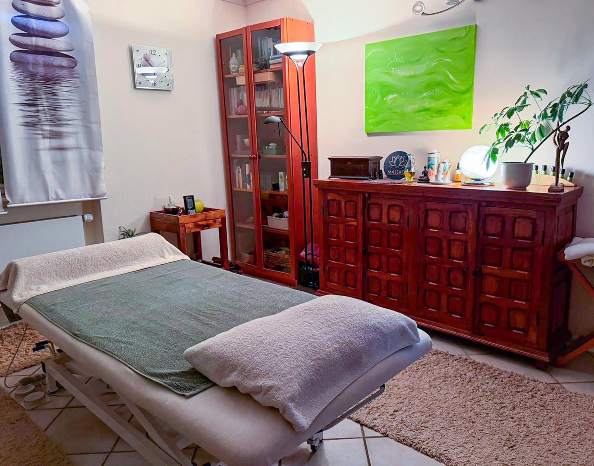 Behandlungsraum mit Massageliege und Steine-Vorhängen